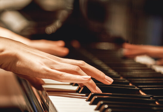 Favorite classical music...Close up view of gentle female hands playing a melody on piano while taking piano lessons