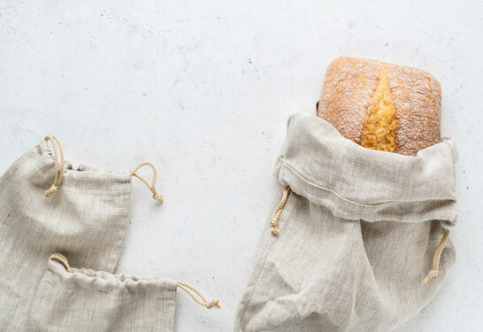 Homemade bread stored in a reusable linen bag with drawstring. Eco friendly Zero waste concept.