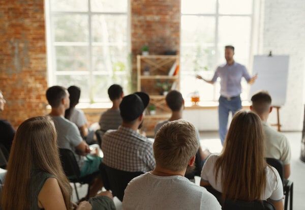 Male speaker giving presentation in hall at university workshop