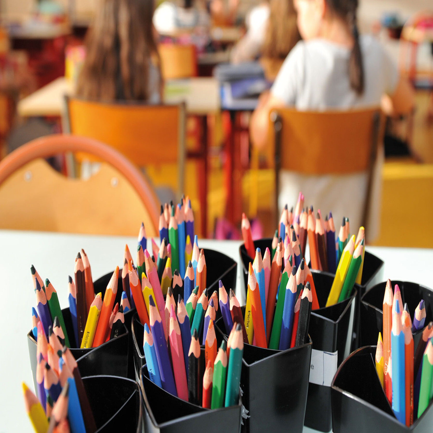 headerPhoto de pots de crayon avec élèves en fond © Bruno Derbord Ville de Niort