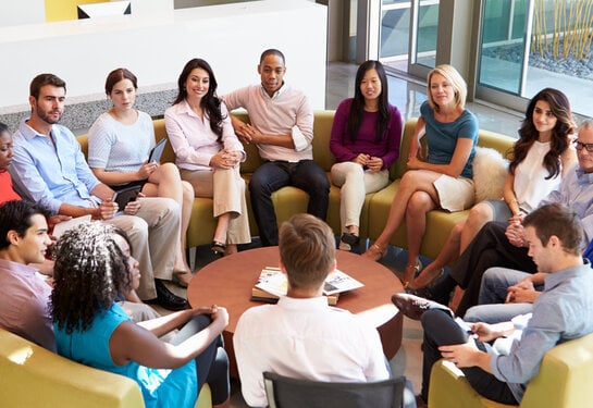 Multi-Cultural Office Staff Sitting Having Meeting Together