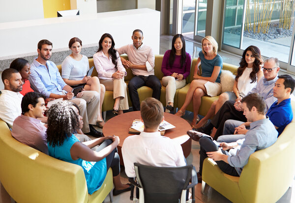 Multi-Cultural Office Staff Sitting Having Meeting Together