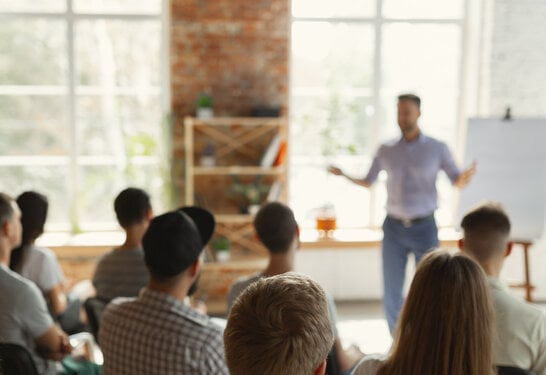 Male speaker giving presentation in hall at university workshop