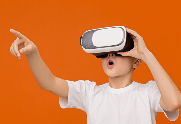 Little excited boy experiencing virtual reality, copy space