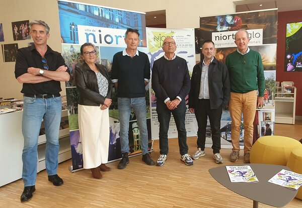 Les organisateurs et élus posent lors de la conférence de presse de présentation, devant les bannières institutionnelles et l'écran du festival.