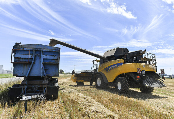 Moisson de ble par un agriculteur niortais avec en fond la ville de Niort