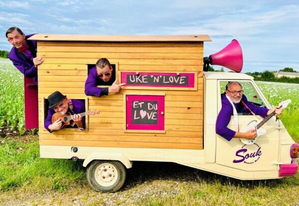 Les musiciens du S.O.U.K en tenues violettes posent avec leur triporteur scénique, un mégaphone rose géant et leurs ukulélés