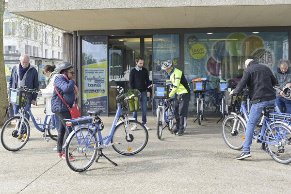 Façade de l'agence Tanlib place de la Brèche, avec des vélos en libre-service et des usagers devant l'entrée.