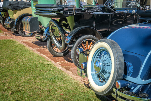 Rear view of vintage cars lined up at classic auto show in city park