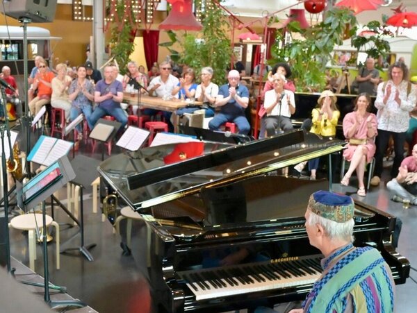 Jeff Gardner interprète un morceau au piano à queue devant un public attentif et applaudissant