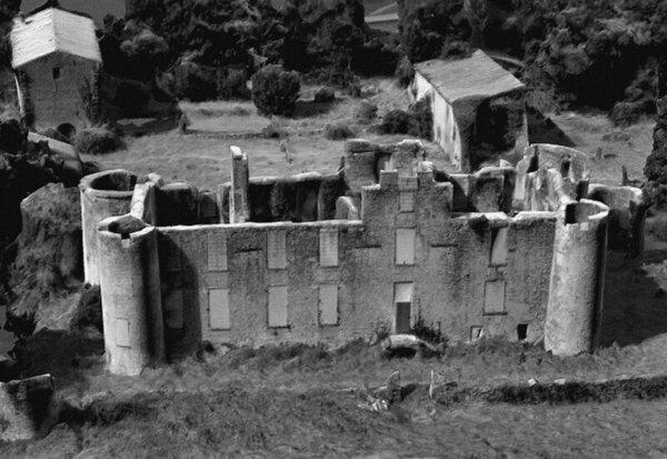 Château de Mursay en ruines depuis les airs, en noir et blanc : tours circulaires d'angle et murs partiellement écroulés