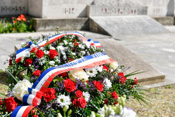 Gerbe tricolore fleurie portant le ruban du Conseil municipal, déposée au pied du monument aux Morts